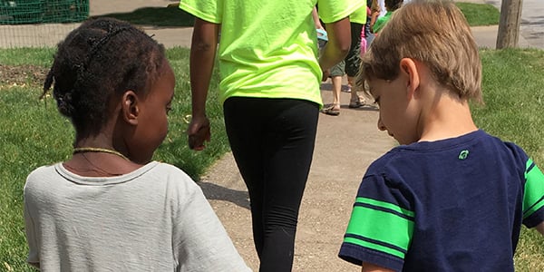 Two kids holding hands walking